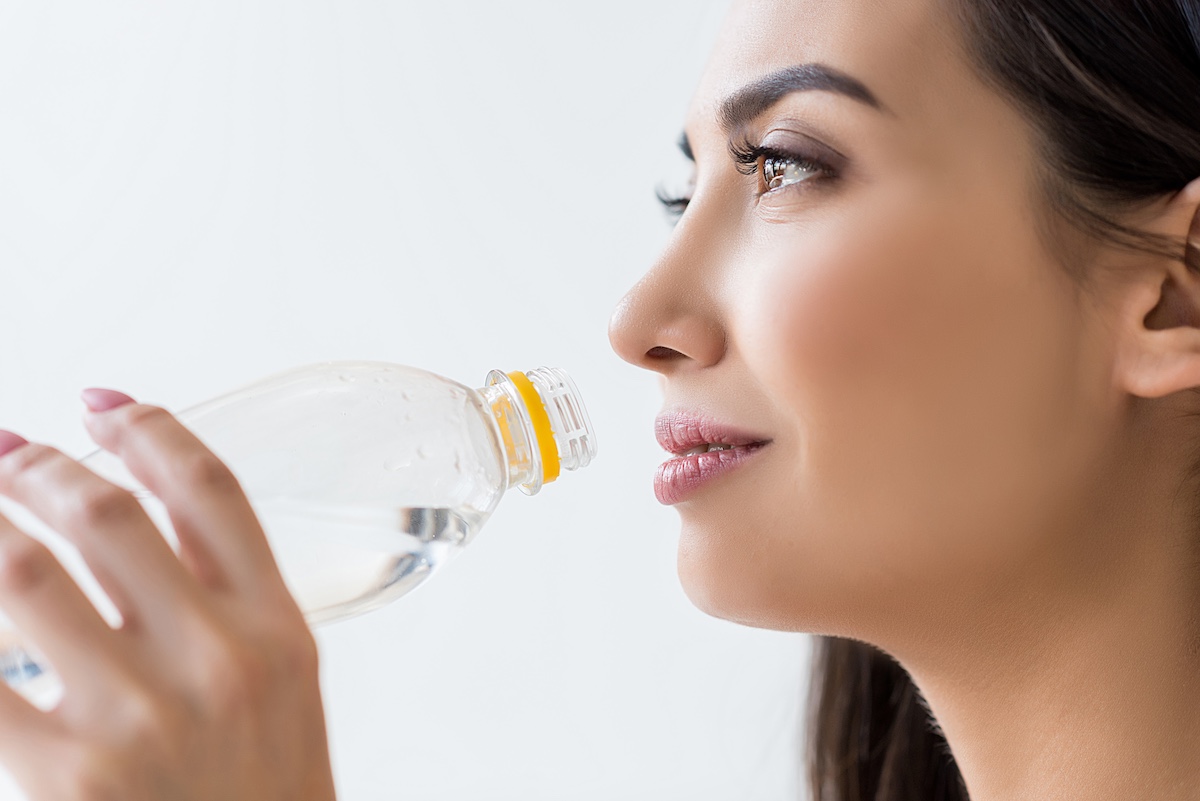 Femme asiatique buvant de l'eau dans une bouteille