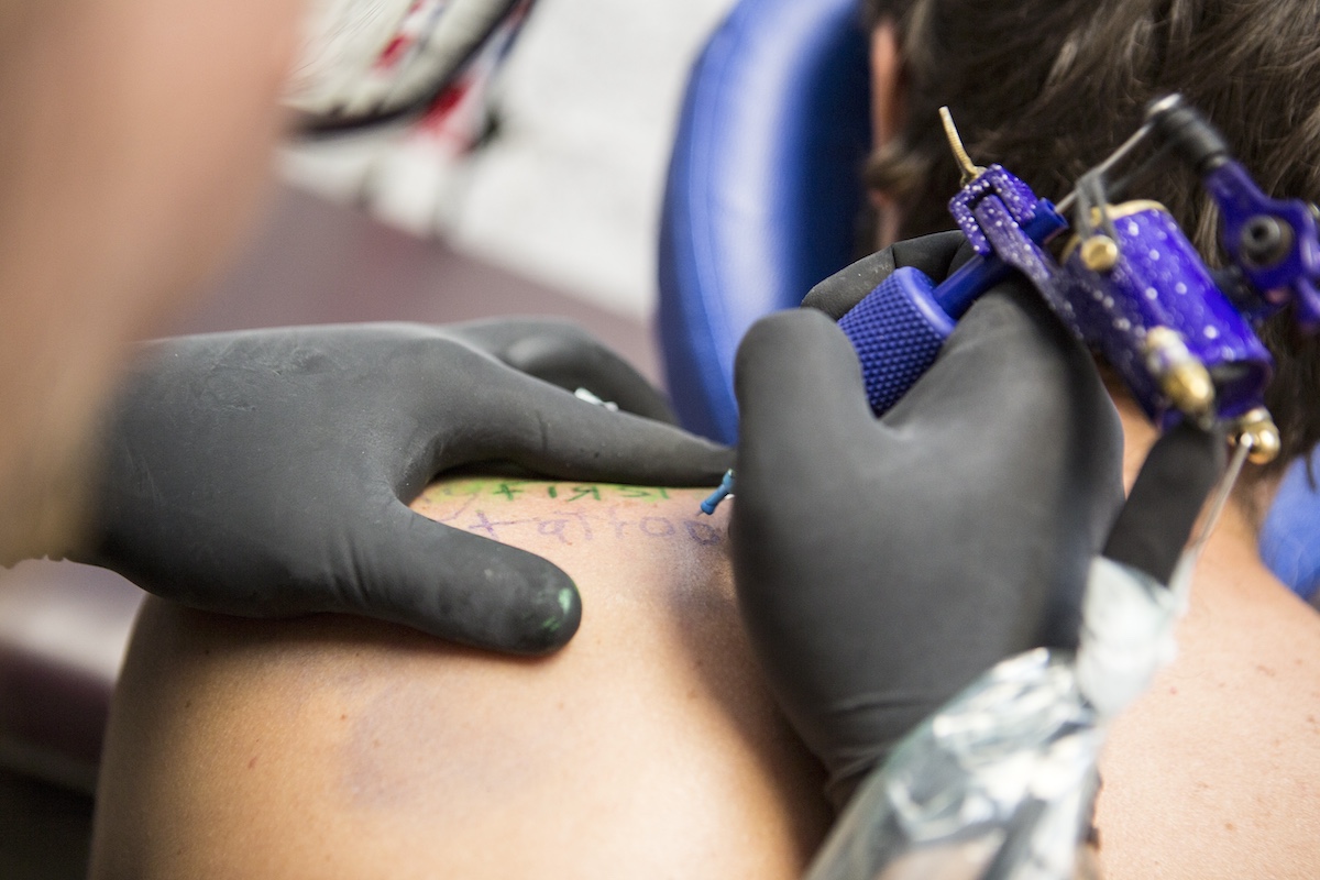 Close Up Of Tattooist Giving Customer Their First Tattoo