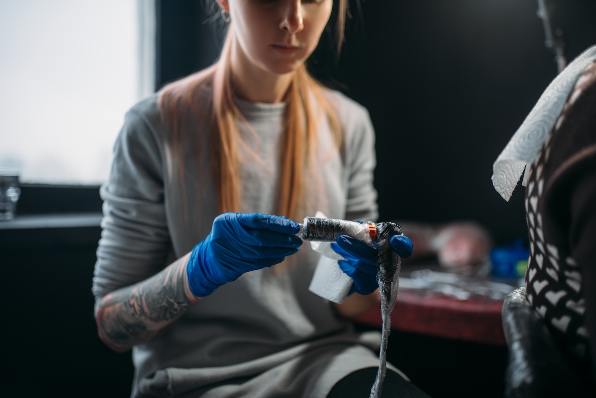 Female Tattooist Prepares Tattoo Machine